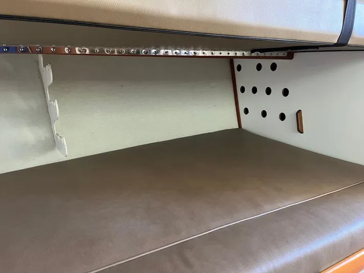  Yacht Photos Pics 1993 Radovich 34 interior cabin with brown cushioned seating and perforated wall design.