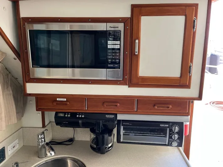  Yacht Photos Pics Compact kitchen area in a 1993 Radovich 34 boat with microwave, coffee maker, and toaster oven.