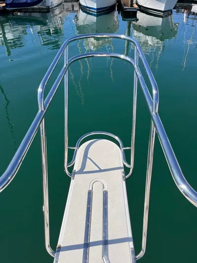  Yacht Photos Pics Radovich 34 boat bow with stainless steel railings, docked in calm marina waters.