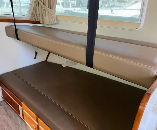  Yacht Photos Pics Interior of a 1993 Radovich 34 boat with brown leather seating and wooden storage.