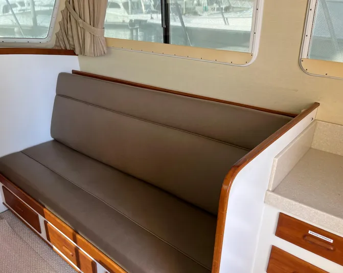  Yacht Photos Pics Interior of a 1993 Radovich 34 boat with brown cushioned seating and wooden accents.