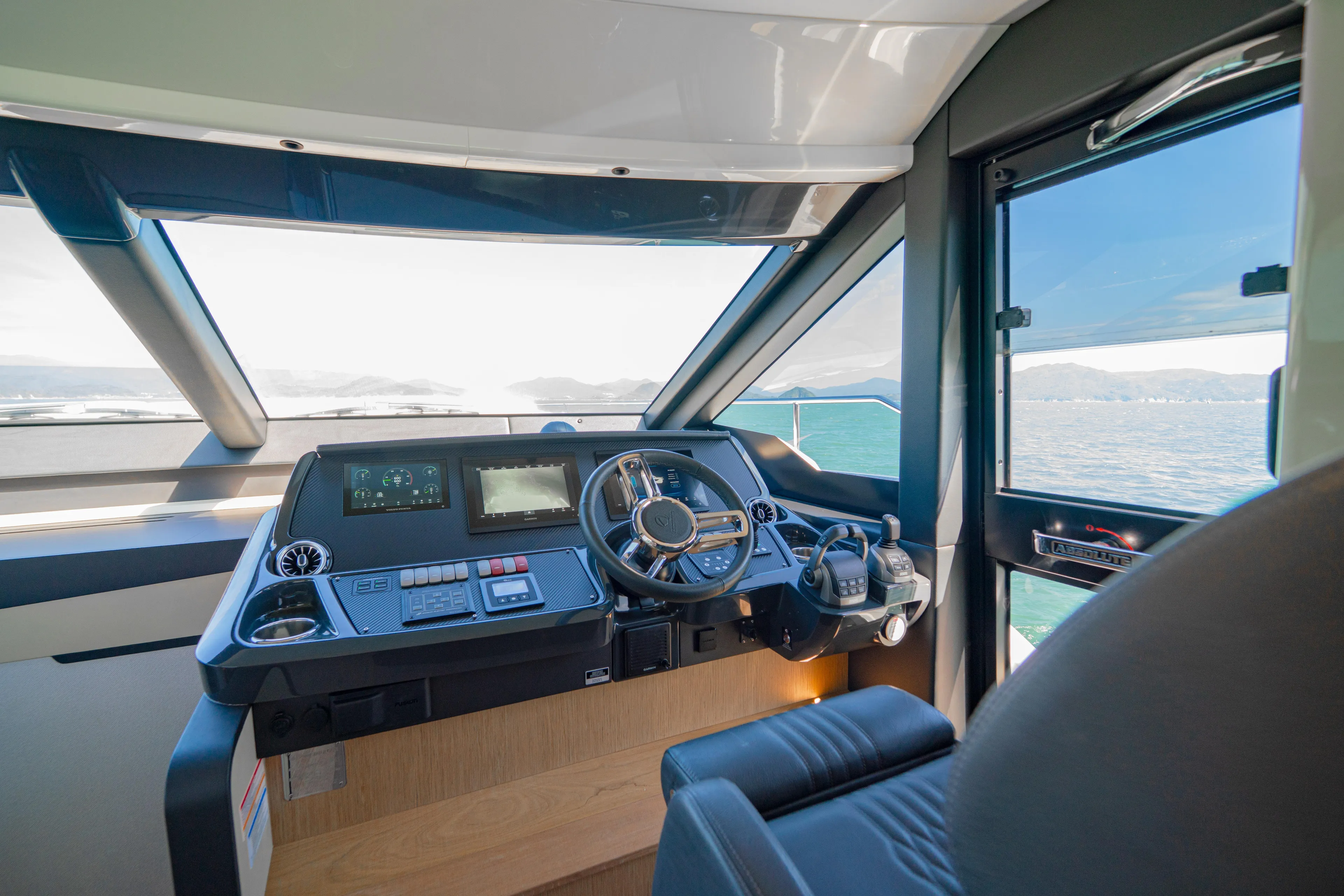 Yacht Photos Pics Interior helm of 2022 Absolute 56 FLY yacht with modern controls and ocean view.