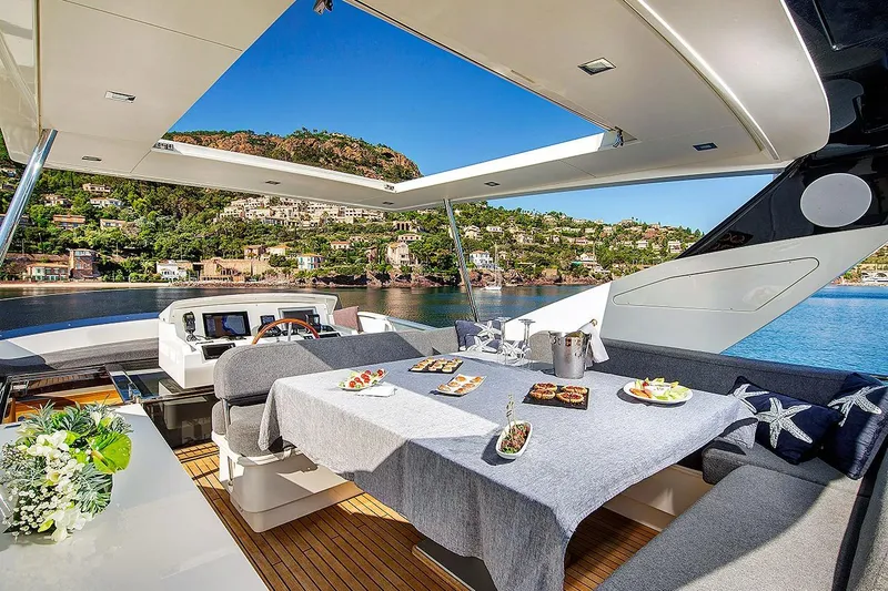 Armonee Yacht Photos Pics Luxurious 2017 Couach 2300 Fly yacht with elegant dining area and scenic coastal view.