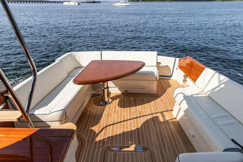 Paddy Wagon Yacht Photos Pics 2017 Hinckley Talaria 43 Flybridge yacht with elegant seating and wooden table on deck.