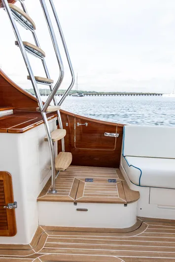 Paddy Wagon Yacht Photos Pics Hinckley Talaria 43 Flybridge 2017, elegant wooden interior, ladder, and seating area by the water.
