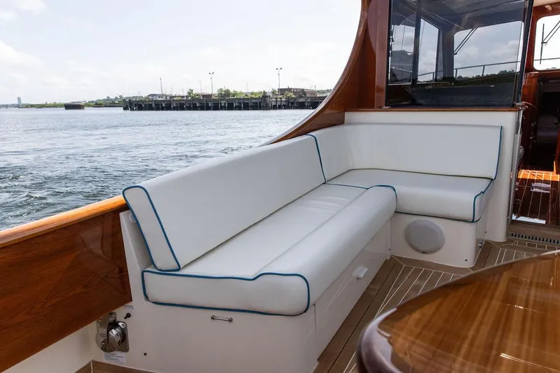 Paddy Wagon Yacht Photos Pics Luxurious seating on 2017 Hinckley Talaria 43 Flybridge yacht, overlooking serene waterfront.