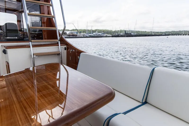 Paddy Wagon Yacht Photos Pics 2017 Hinckley Talaria 43 Flybridge yacht with elegant seating and polished wood table by the water.