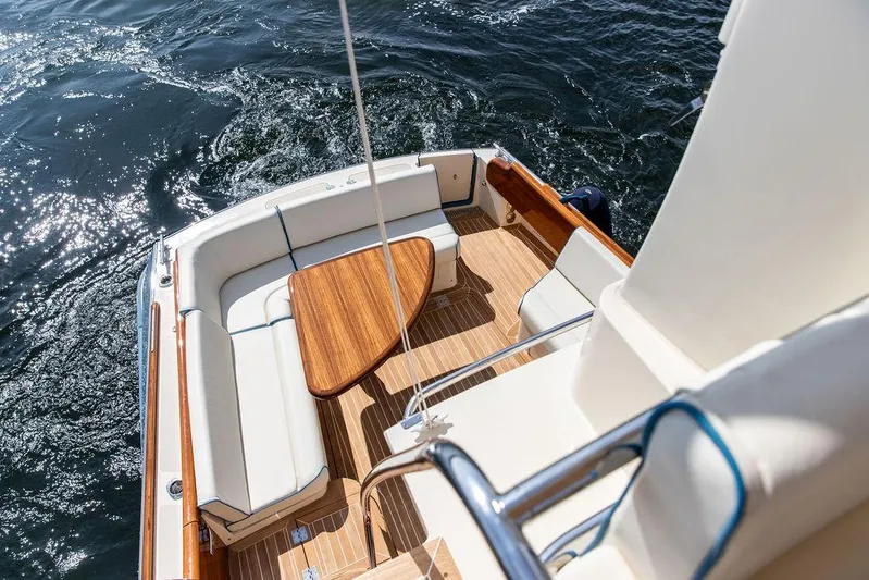 Paddy Wagon Yacht Photos Pics 2017 Hinckley Talaria 43 Flybridge with elegant seating and wooden table on deck.