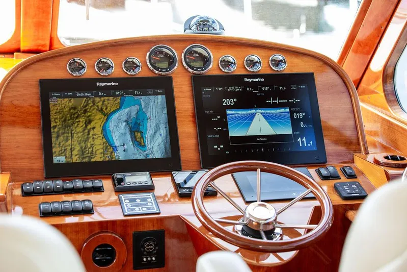 Paddy Wagon Yacht Photos Pics Hinckley Talaria 43 Flybridge 2017 helm with Raymarine navigation displays and wooden steering wheel.