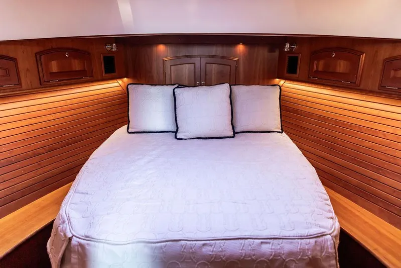Paddy Wagon Yacht Photos Pics Luxurious cabin interior of 2017 Hinckley Talaria 43 Flybridge with cozy bedding and wood paneling.