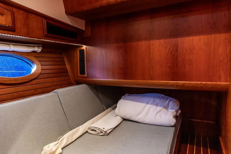 Paddy Wagon Yacht Photos Pics Cozy cabin interior of 2017 Hinckley Talaria 43 Flybridge with wooden paneling and porthole.