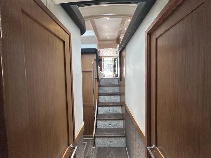 Here & Now 2017 Sea Ray 510 Fly @ Acapulco Yacht Photos Pics Interior hallway of 2017 Sea Ray Fly 510 yacht with wooden doors and carpeted stairs.
