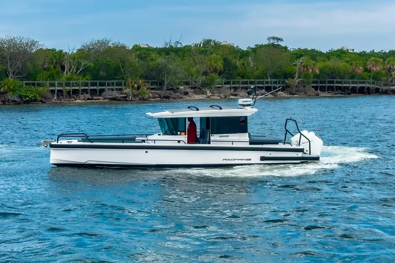  Yacht Photos Pics 2022 Axopar 28 Cabin BRABUS Trim boat cruising on a scenic waterway.