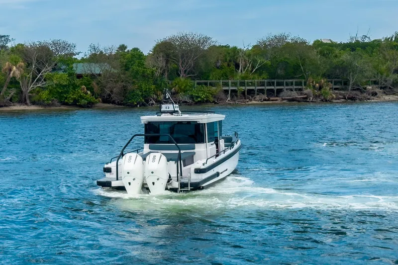  Yacht Photos Pics 2022 Axopar 28 Cabin BRABUS Trim cruising on a scenic waterway.