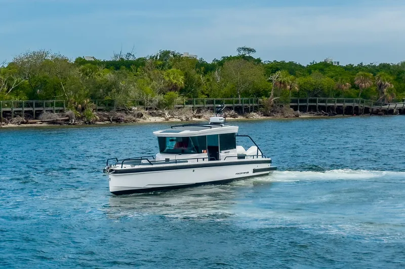  Yacht Photos Pics 2022 Axopar 28 Cabin BRABUS Trim cruising on a scenic waterway.