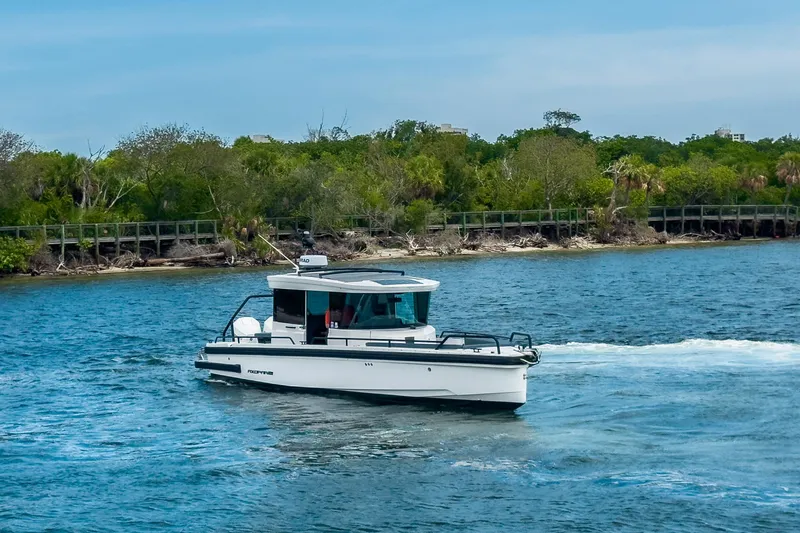  Yacht Photos Pics 2022 Axopar 28 Cabin BRABUS Trim boat cruising on a scenic waterway.