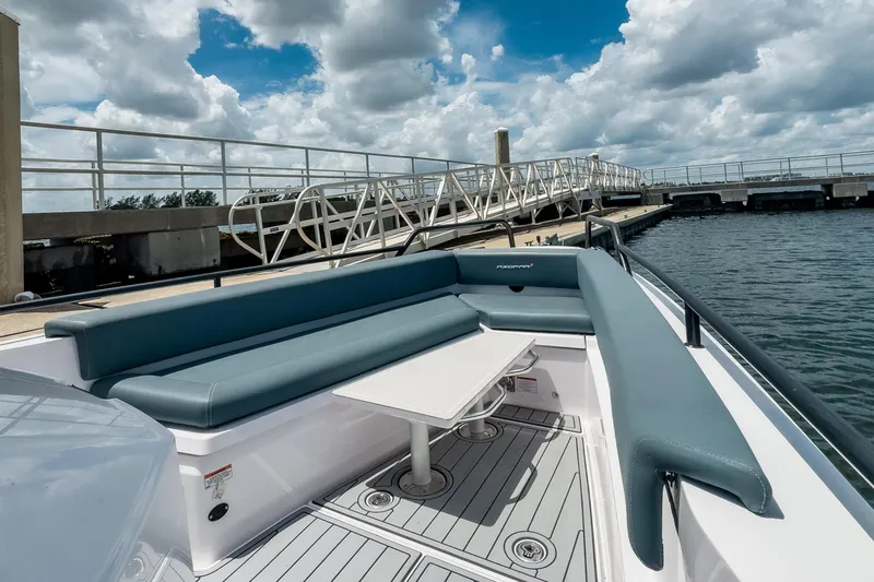  Yacht Photos Pics 2022 Axopar 28 Cabin BRABUS Trim boat with sleek seating and table, docked by the water.