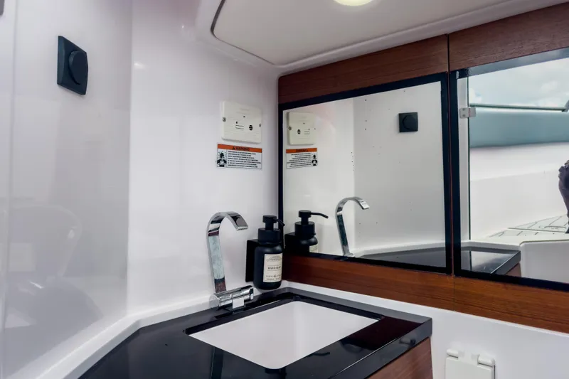  Yacht Photos Pics Luxurious bathroom interior of 2022 Axopar 28 Cabin BRABUS Trim with sleek sink and mirror.