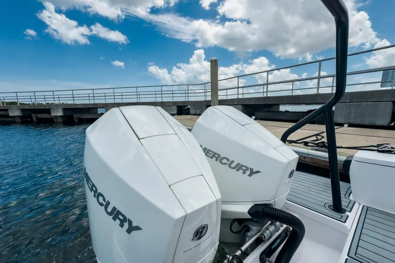  Yacht Photos Pics 2022 Axopar 28 Cabin BRABUS Trim with dual Mercury outboard engines docked by a pier.