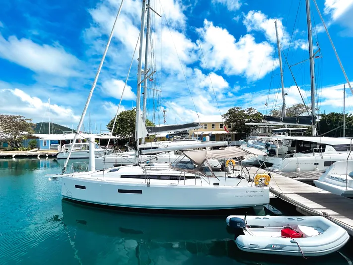 Calypso Express Yacht Photos Pics 2024 Jeanneau Sun Odyssey 380 sailboat docked in a marina under a bright blue sky.