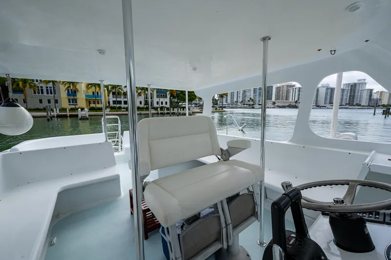  Yacht Photos Pics 2019 Aventura 31 Cat interior with steering wheel, seating, and waterfront view.
