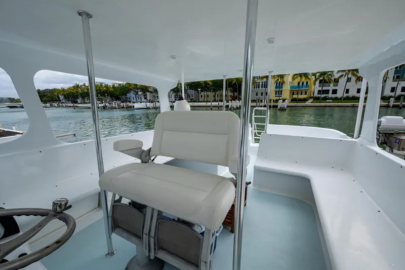  Yacht Photos Pics 2019 Aventura 31 Cat interior with white seating, steering wheel, and waterfront view.