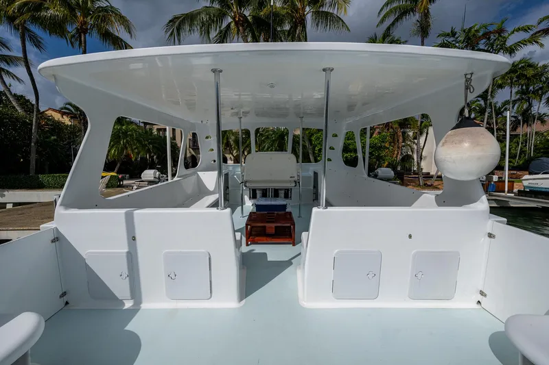  Yacht Photos Pics 2019 Aventura 31 Cat boat with spacious deck and canopy, surrounded by palm trees.