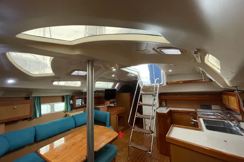  Yacht Photos Pics Interior of 1999 Hunter Passage 420 sailboat with seating, table, and kitchen area.