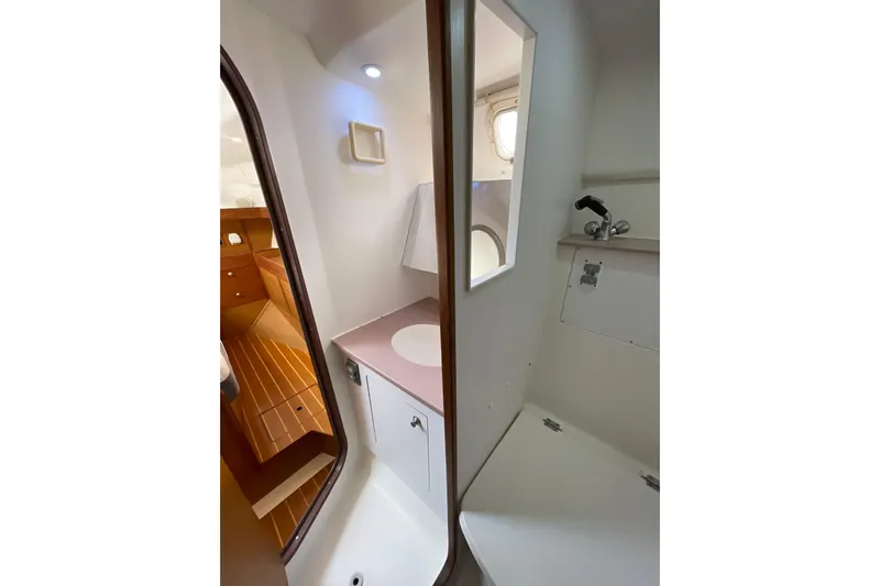  Yacht Photos Pics 1999 Hunter Passage 420 yacht bathroom with sink, mirror, and wooden flooring.