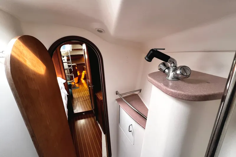  Yacht Photos Pics Interior of 1999 Hunter Passage 420 yacht, featuring wooden flooring and compact sink area.