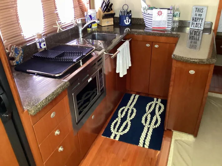  Yacht Photos Pics 2006 Sea Ray 48 Sundancer kitchen with wooden cabinets, granite countertops, and nautical decor.