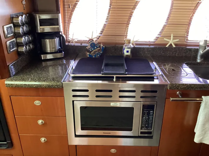  Yacht Photos Pics Galley kitchen in 2006 Sea Ray 48 Sundancer with microwave, coffee maker, and starfish decor.