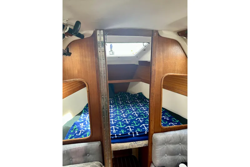 Makai Yacht Photos Pics Interior of a 1999 Catalina 320 sailboat with anchor-patterned bedding.