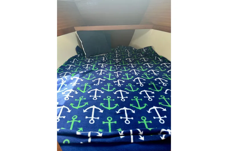 Makai Yacht Photos Pics Cozy cabin bed in 1999 Catalina 320 sailboat with anchor-patterned blanket.