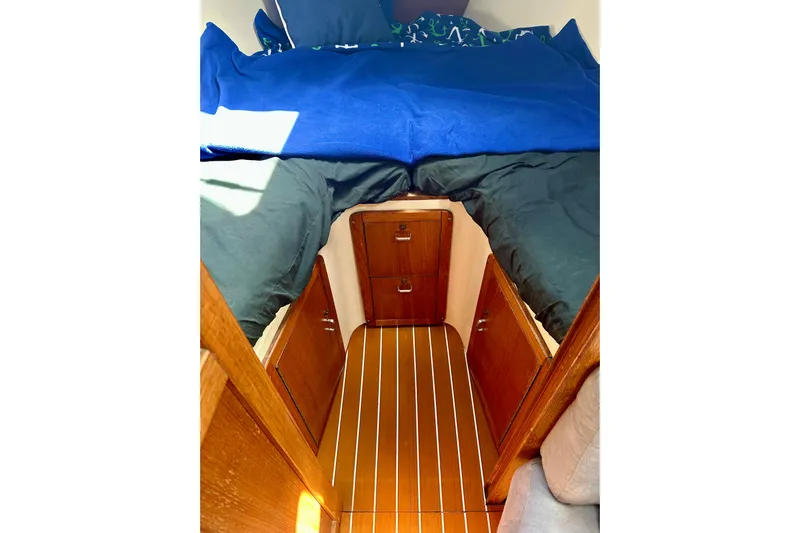 Makai Yacht Photos Pics Cozy cabin interior of 1999 Catalina 320 sailboat with wooden finish and bedding.