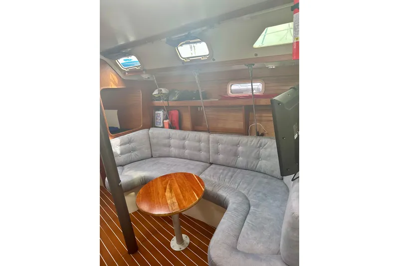 Makai Yacht Photos Pics Interior of 1999 Catalina 320 sailboat with cozy seating and wooden table.