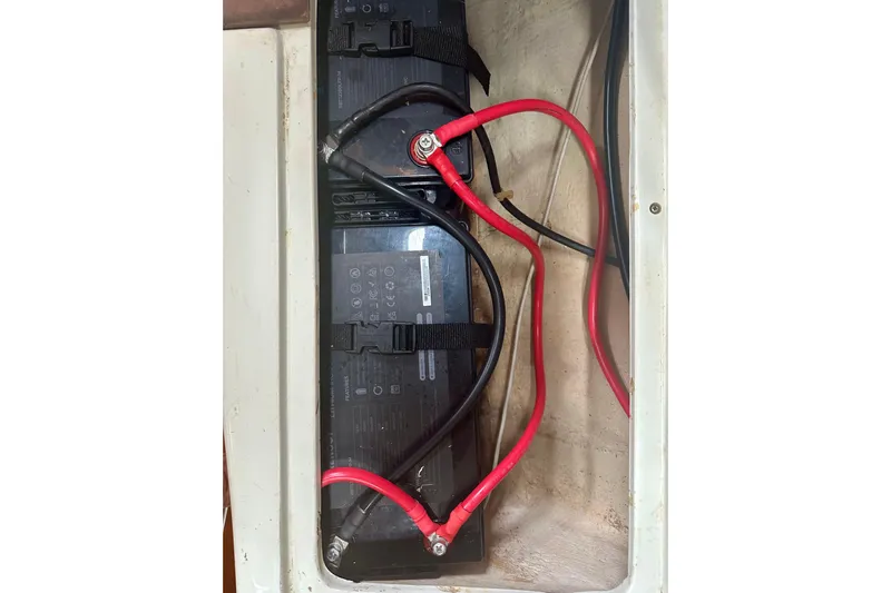 Makai Yacht Photos Pics Battery compartment of a 1999 Catalina 320 sailboat with red and black cables.