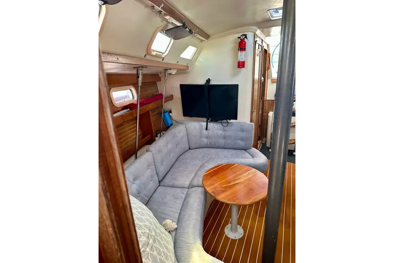 Makai Yacht Photos Pics Interior of 1999 Catalina 320 sailboat with cozy seating and wooden table.