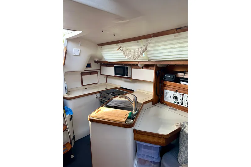 Makai Yacht Photos Pics Interior of 1999 Catalina 320 sailboat kitchen with wooden accents and modern appliances.