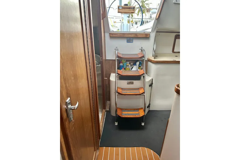 Makai Yacht Photos Pics Interior of 1999 Catalina 320 sailboat with wooden steps and storage shelves.
