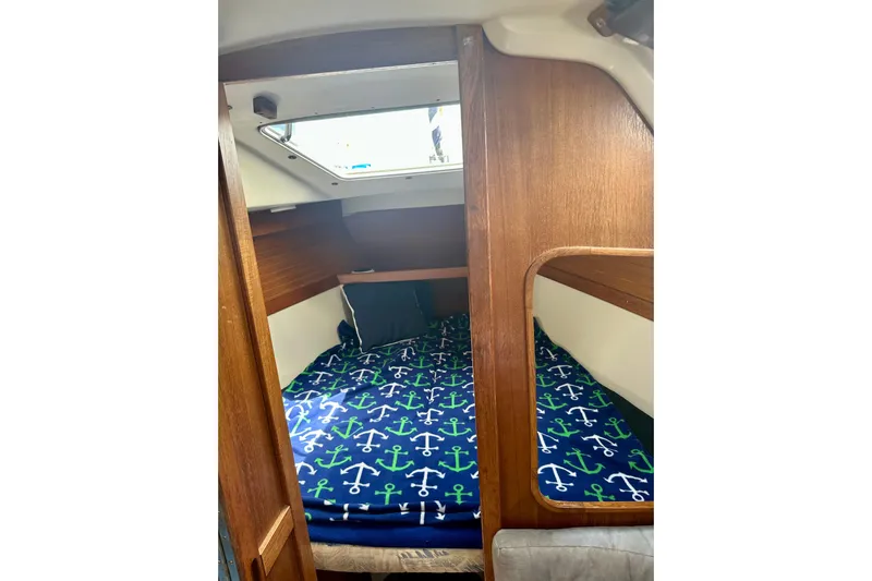 Makai Yacht Photos Pics Cozy cabin interior of 1999 Catalina 320 sailboat with anchor-themed bedding.