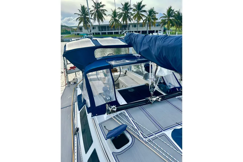 Makai Yacht Photos Pics Catalina 320 sailboat, 1999 model, docked with blue canopy and palm trees in background.