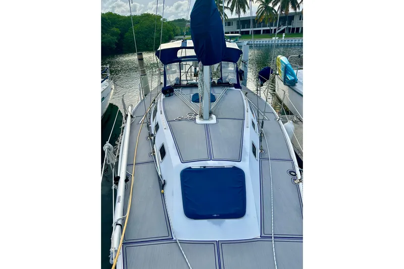 Makai Yacht Photos Pics Sailboat docked in marina, 1999 Catalina 320 model, with blue accents and lush surroundings.