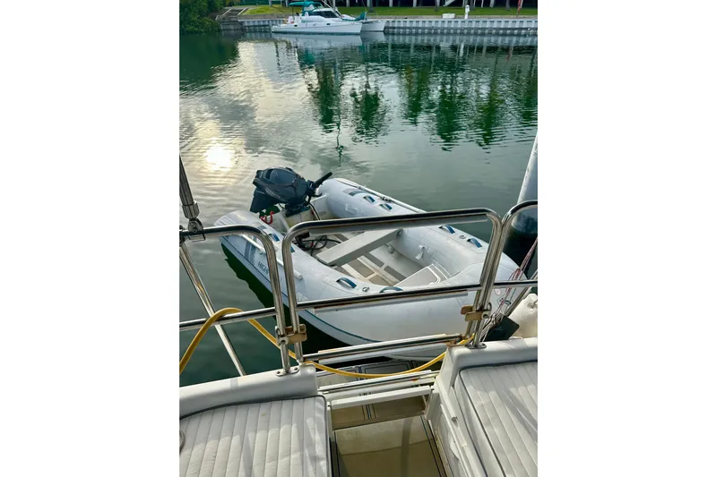 Makai Yacht Photos Pics Catalina 320 sailboat, 1999 model, docked with inflatable dinghy on calm water.