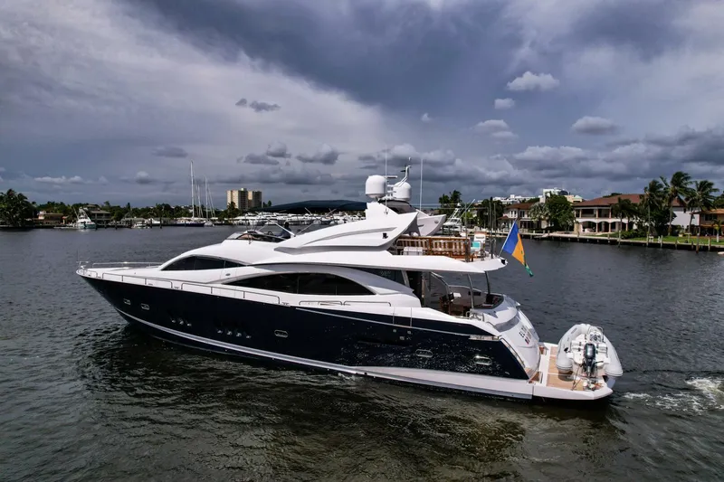 El Tio Yacht Photos Pics Luxurious 2006 Sunseeker 90 Yacht cruising on a scenic waterway under cloudy skies.