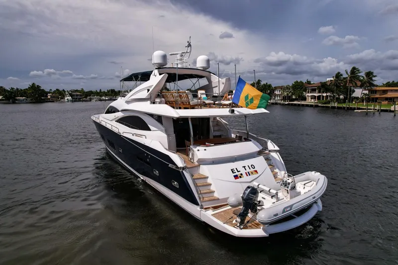 El Tio Yacht Photos Pics Luxury 2006 Sunseeker 90 Yacht on water, displaying vibrant flag, elegant design.