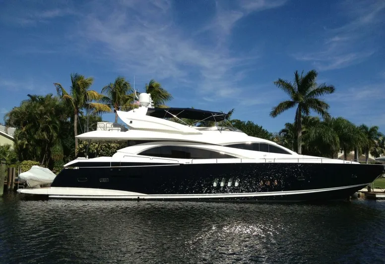 El Tio Yacht Photos Pics Sunseeker 90 Yacht 2006 docked by palm trees under clear blue sky.