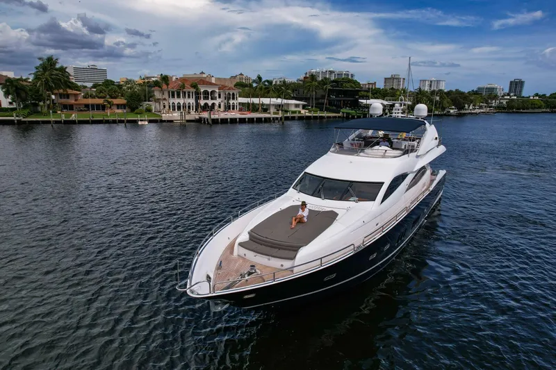 El Tio Yacht Photos Pics 2006 Sunseeker 90 Yacht cruising on a scenic waterway with luxurious waterfront homes.