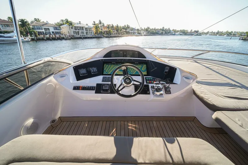 El Tio Yacht Photos Pics Helm of 2006 Sunseeker 90 Yacht with modern controls, overlooking serene waterfront homes.