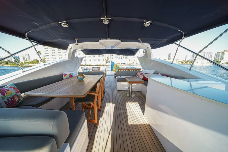 El Tio Yacht Photos Pics Luxurious 2006 Sunseeker 90 Yacht deck with seating, table, and canopy, overlooking waterfront.